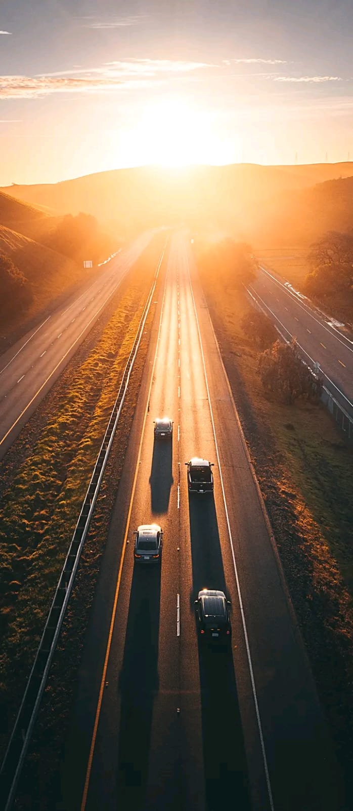 Ruta al atardecer con vehículos en circulación